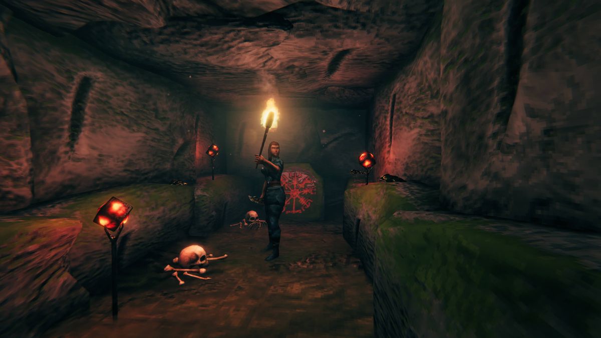 Valheim player carrying a torch inside a burial chamber